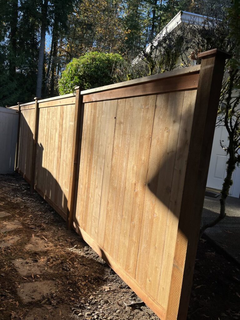 A long section of a newly installed wooden fence providing privacy and security by Guzmanremodeling LlC in Renton, WA.