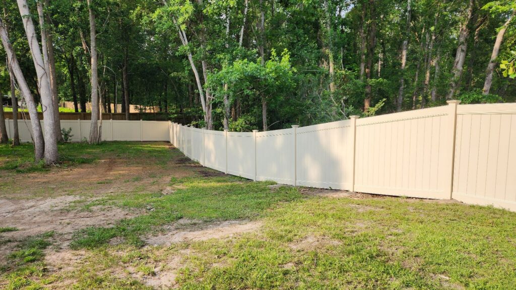 A long stretch of newly installed light-colored vinyl privacy fence by Fence & Deck Connection, Inc. in Savannah, GA.