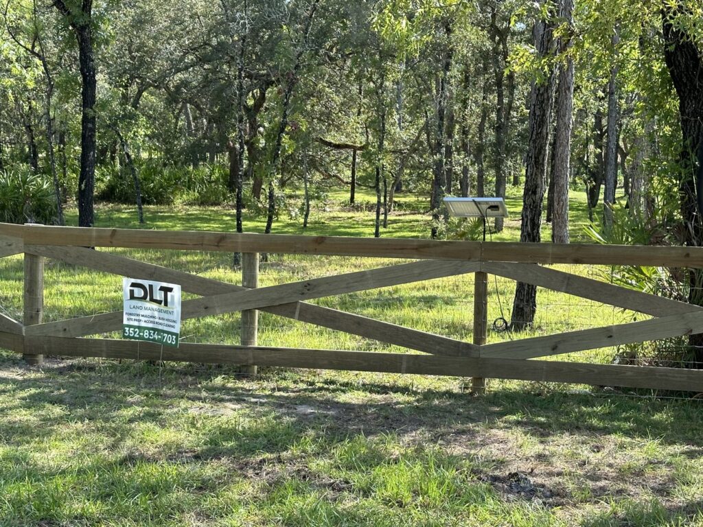 A long, newly constructed wooden farm fence alongside a road, completed by DLT Land Management in Tampa, FL.