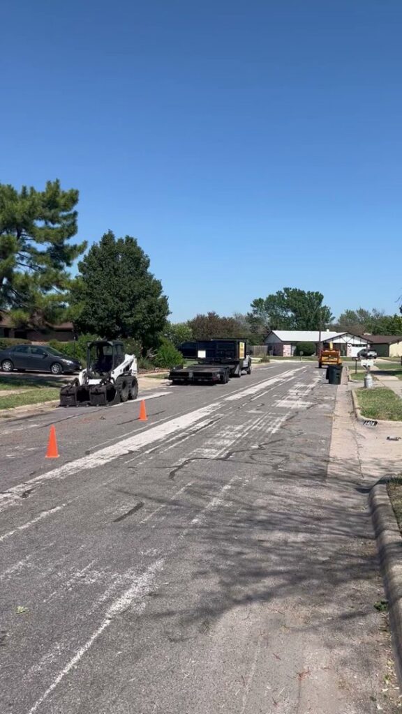 Lot clearing equipment, including a Bobcat loader and trailer, on a street for A. Matt Tree Service in Fort Worth, TX.