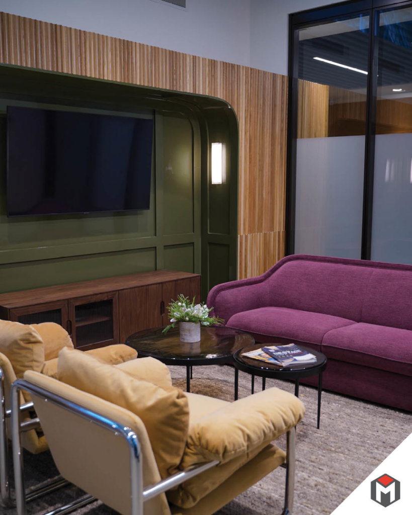 A comfortable lounge area featuring a wall-mounted TV and decorative wall paneling by Miranda Construction in Louisville, KY.