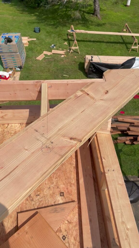 Lumber and construction tools on a partially framed roof or floor by LCM FRAMING LLC in Danbury, CT