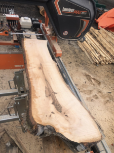 A LumberMAX portable sawmill cutting a large log into lumber for Dancing Bear Woodworks in Spokane, WA.