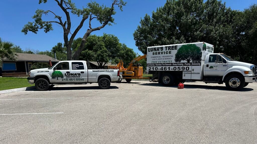 Two Luna's Tree Service trucks and a wood chipper parked on a sunny day in San Antonio, TX.