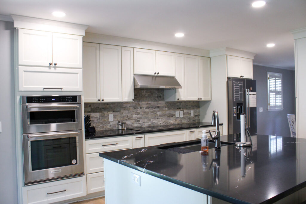 Luxurious bathroom remodel with marble walls, double vanity, and gold accents by Prestige Remodeling Solutions in Jackson, TN.