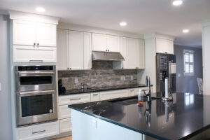 Luxurious bathroom remodel with marble walls, double vanity, and gold accents by Prestige Remodeling Solutions in Jackson, TN.