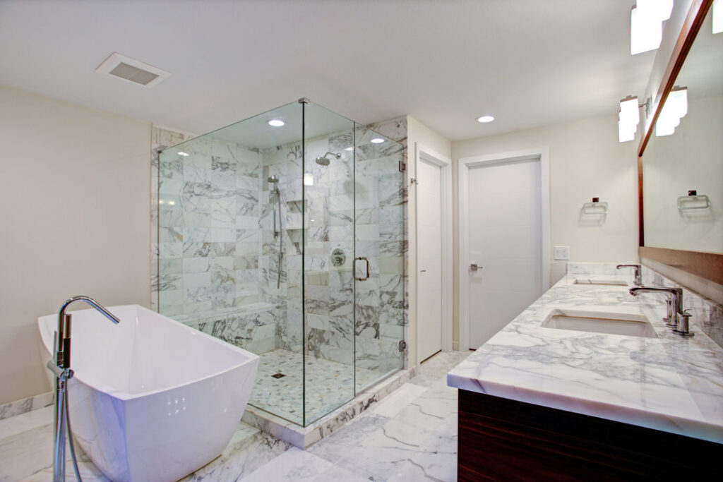 A luxurious bathroom remodel featuring a freestanding tub, walk-in shower with marble tiles, and a double vanity by The Bath Shop in Raleigh, NC.