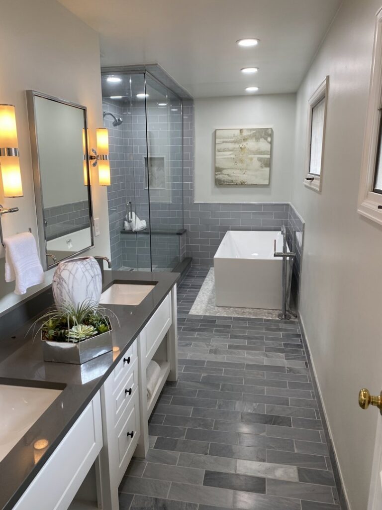 A luxurious bathroom renovation featuring a double vanity, large shower, and freestanding tub by Infinite Creations Construction, LLC in Denver, CO