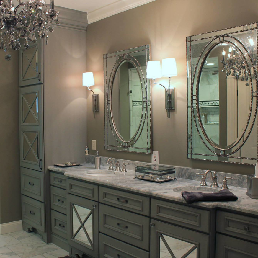 A luxurious bathroom vanity installation with grey cabinets, marble countertop, and ornate mirrors by Davinci Cabinets & Design in St. Louis, MO.