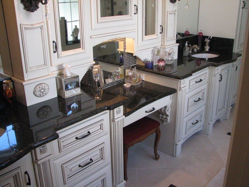 A luxurious bathroom vanity featuring multiple white cabinets, sinks, and a makeup area, completed by Metro Contractors & Supply, Inc. in Norman, OK