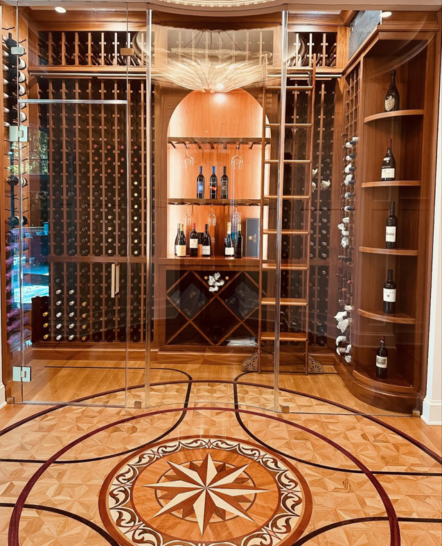 Luxurious custom wood wine cellar with glass doors and intricate flooring by Lardieri's Custom Woodworking Company, Inc. in Lakewood, NJ.