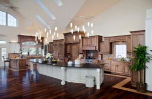 A luxurious kitchen renovation featuring custom wooden cabinets, dark countertops, and hardwood flooring by Surfaces By Design in Duluth, MN.