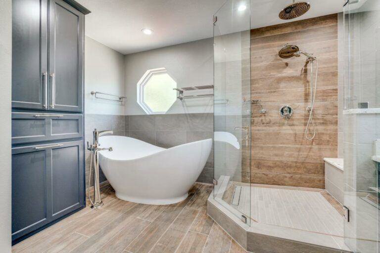 A luxurious bathroom featuring a unique freestanding tub, glass shower, and built-in storage by DFW Improved in Plano, TX.