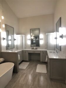 A luxurious bathroom remodel featuring multiple vanities, a freestanding tub, and modern lighting by Ignite Construction in Tempe, AZ.
