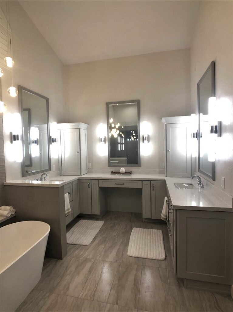 A luxurious bathroom remodel featuring multiple vanities, a freestanding tub, and modern lighting by Ignite Construction in Tempe, AZ.