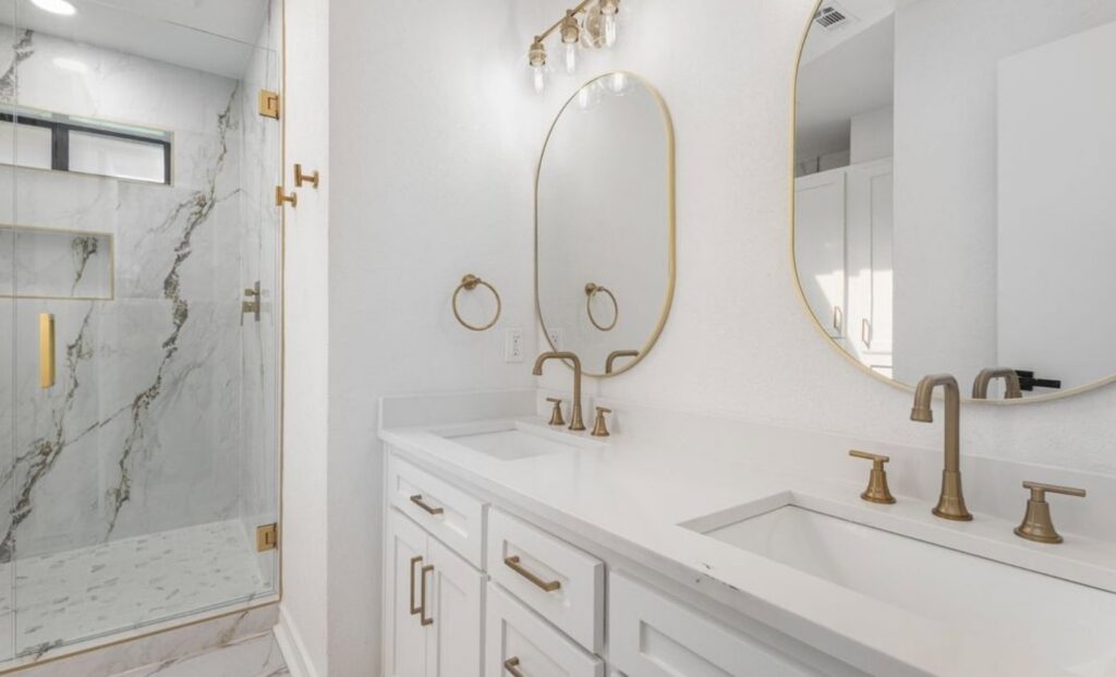 A luxurious bathroom renovation featuring dual vanity, gold fixtures, and a walk-in shower by Home Platinum Services, LLC in Plano, TX
