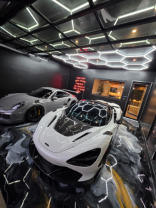 A luxury garage featuring a custom epoxy floor coating and hexagonal lighting by Orange Door Custom Coatings in Phoenix, AZ.