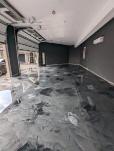 A luxury garage or showroom featuring a custom decorative epoxy floor by Roche Epoxy Floors in Allentown, PA.