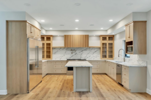 A luxurious kitchen installation with light wood cabinetry and a marble-look backsplash by McDonald Custom Homes in Schenectady, NY.