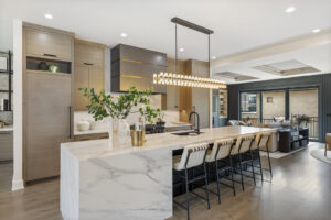 A luxury kitchen featuring a large marble island with seating and modern lighting by DJK Custom Homes in Naperville, IL