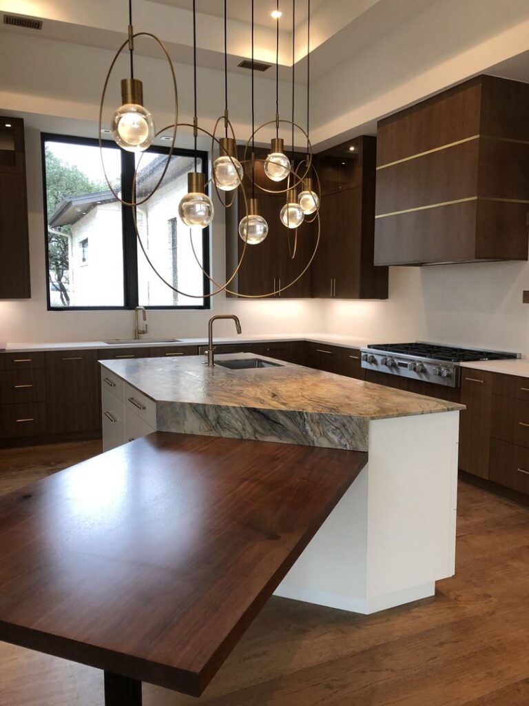 A luxury kitchen renovation with dark wood cabinets and a unique island by Stone Age Granite of Austin, TX.