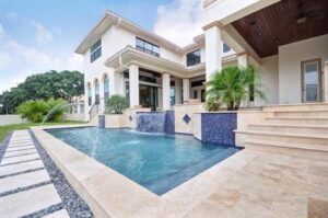 A luxurious multi-story home with an elegant swimming pool and water features, built by TamLin Homes Inc in Tampa, FL