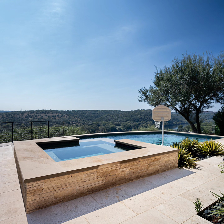 A luxury outdoor swimming pool and patio area overlooking a scenic view by Rockin' Remodeling LLC in Austin, TX