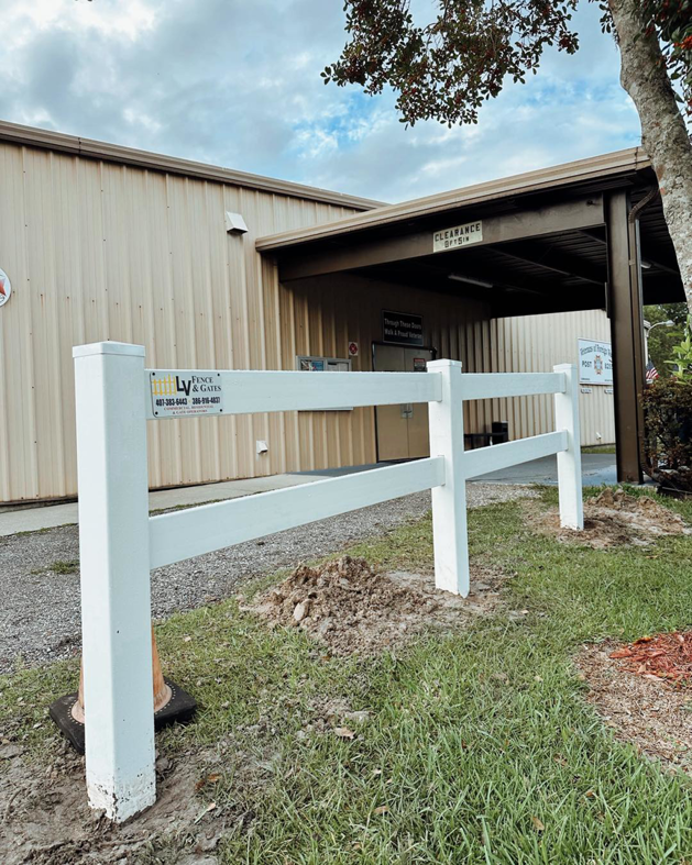 The LV Fence and Gates business logo displayed on a newly installed white vinyl fence post in Jacksonville, FL.