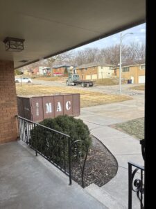 A MAC Containers, Inc dumpster delivered to a residential property with a truck in the background in Omaha, NE.