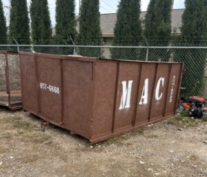 A MAC Containers, Inc dumpster placed on a property for junk removal services in Omaha, NE.