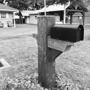 A newly installed black mailbox on a sturdy wooden post by Acadian Carpentry LLC in Lafayette, LA.