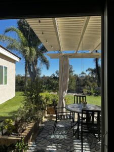 A handyman from Bring The Pane cleaning a large sliding glass door with a long squeegee in Lewiston, ID.