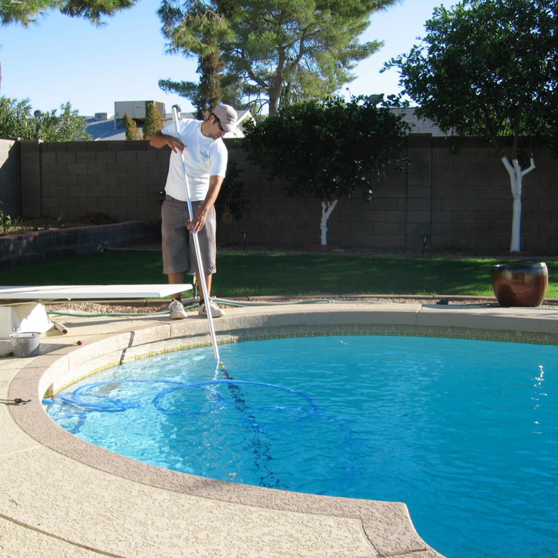 A man performing professional swimming pool cleaning services for Mr. Pools LLC in Gilbert, AZ.