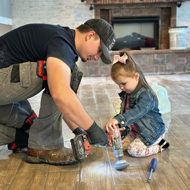 A handyman from Love Anchor Construction LLC drilling into a newly tiled floor in Vancouver, WA.