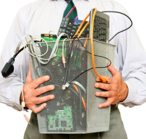 A man holding a bin filled with various electronic waste items for recycling by SES Secure E-Waste Solutions Inc. in San Diego, CA.