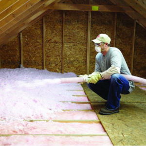 A handyman installing blown-in insulation in an attic for Alternative Weatherization in Fall River, MA.