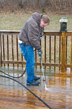 A handyman pressure washing a wooden deck, a service offered by Pocatello Handyman in Pocatello, ID