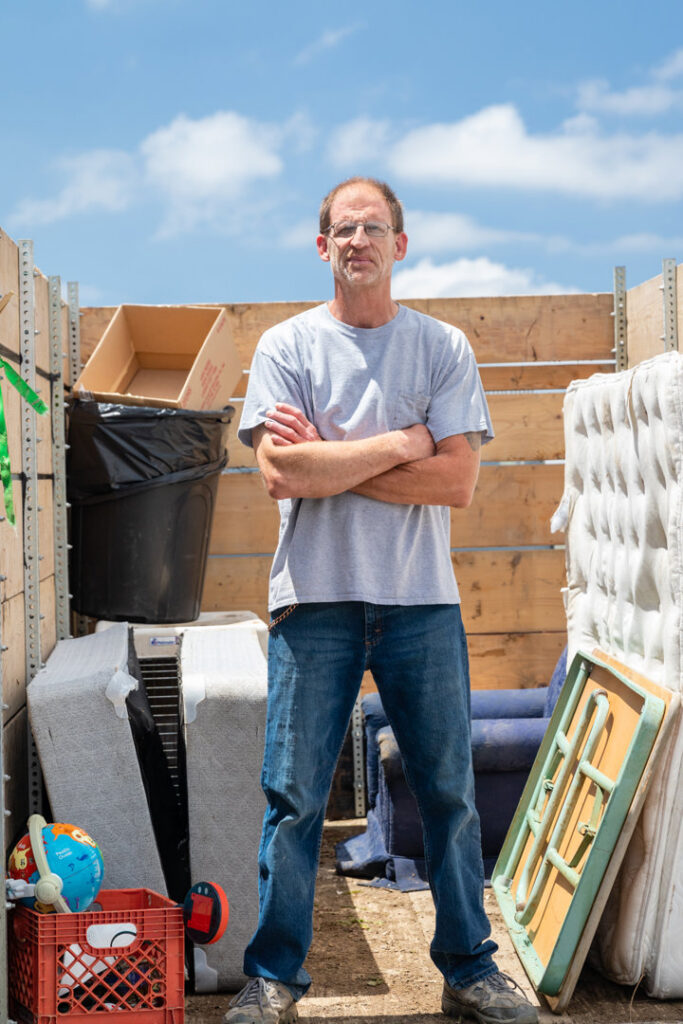 A man standing in front of a truck bed filled with various junk items for A1 Junk Removal Of Tucson, AZ.