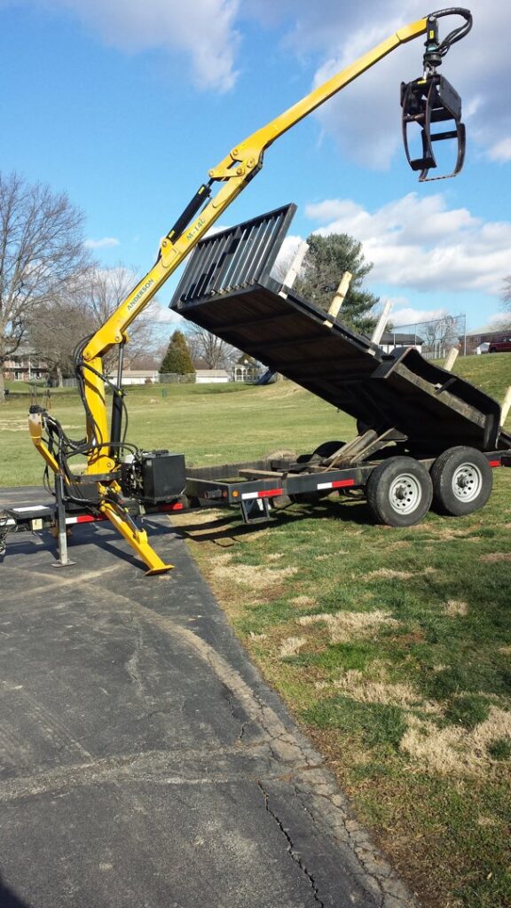 A man trimming a large bush with a hedge trimmer for Douglas Tree & Property Service in Lancaster, PA.