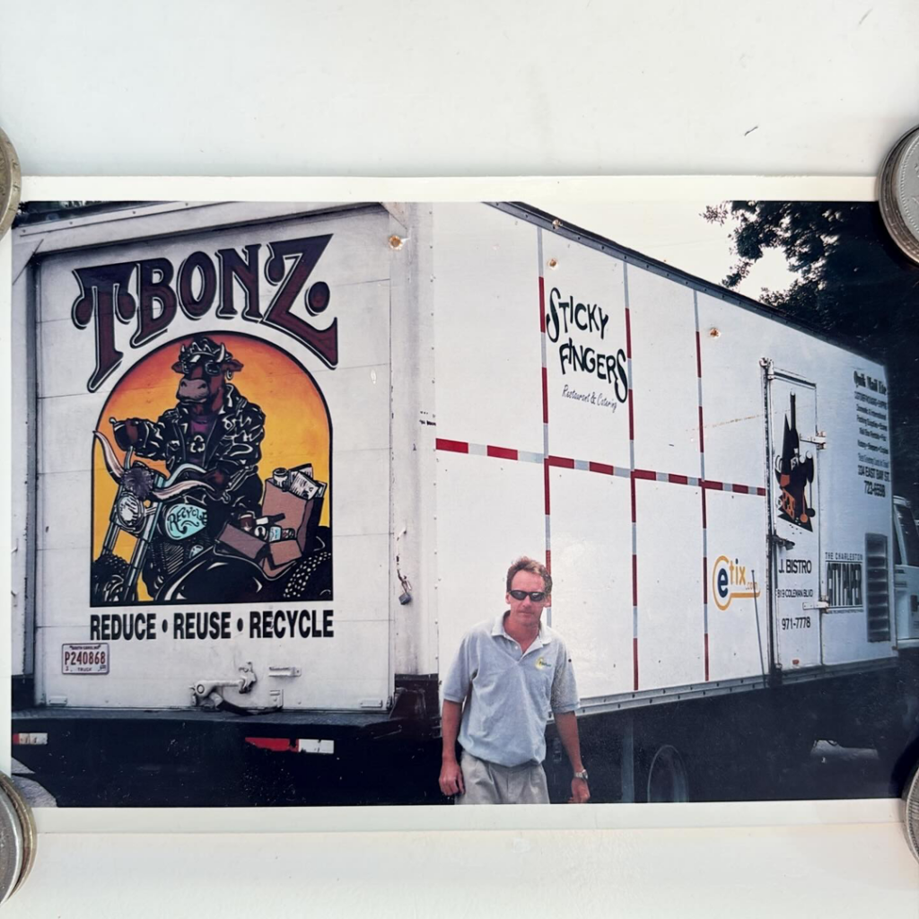 A man standing in front of a recycling truck with 'Reduce, Reuse, Recycle' text for Fisher Recycling in Charleston, SC.