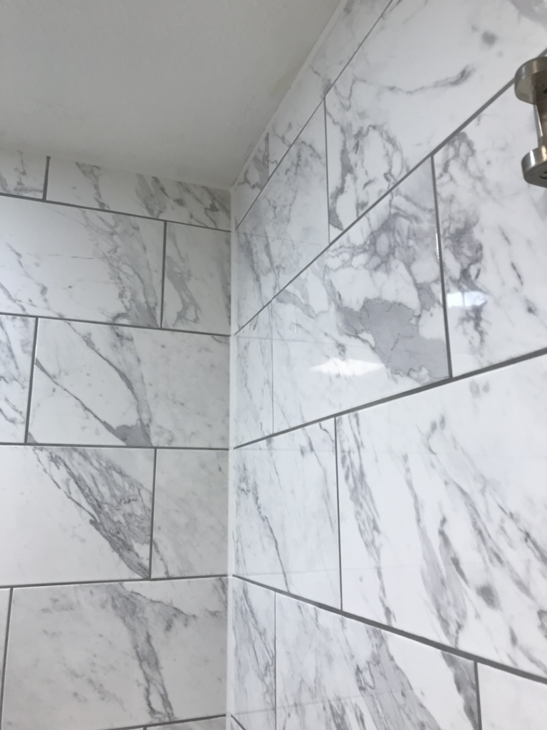 Close-up of elegant marble-look shower tile installation by Davis Home Dynamics in Springfield, OR
