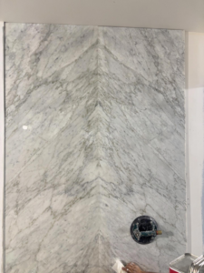 Close-up of marble wall panels with a chevron pattern installed by Golden Tile Construction in Yonkers, NY.