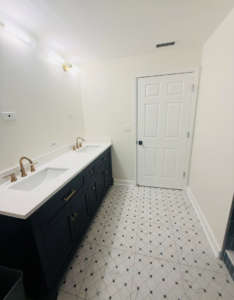 A completed master bathroom renovation with a double vanity and patterned floor tiles by All In Service Group, LLC in Chicago, IL.