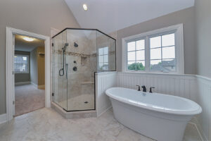 A luxurious master bathroom with a freestanding tub and a large glass shower, built by Autumn Homes in Naperville, IL.