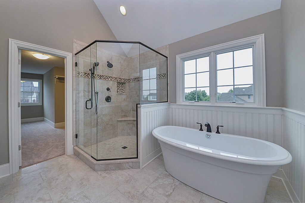 A luxurious master bathroom with a freestanding tub and a large glass shower, built by Autumn Homes in Naperville, IL.