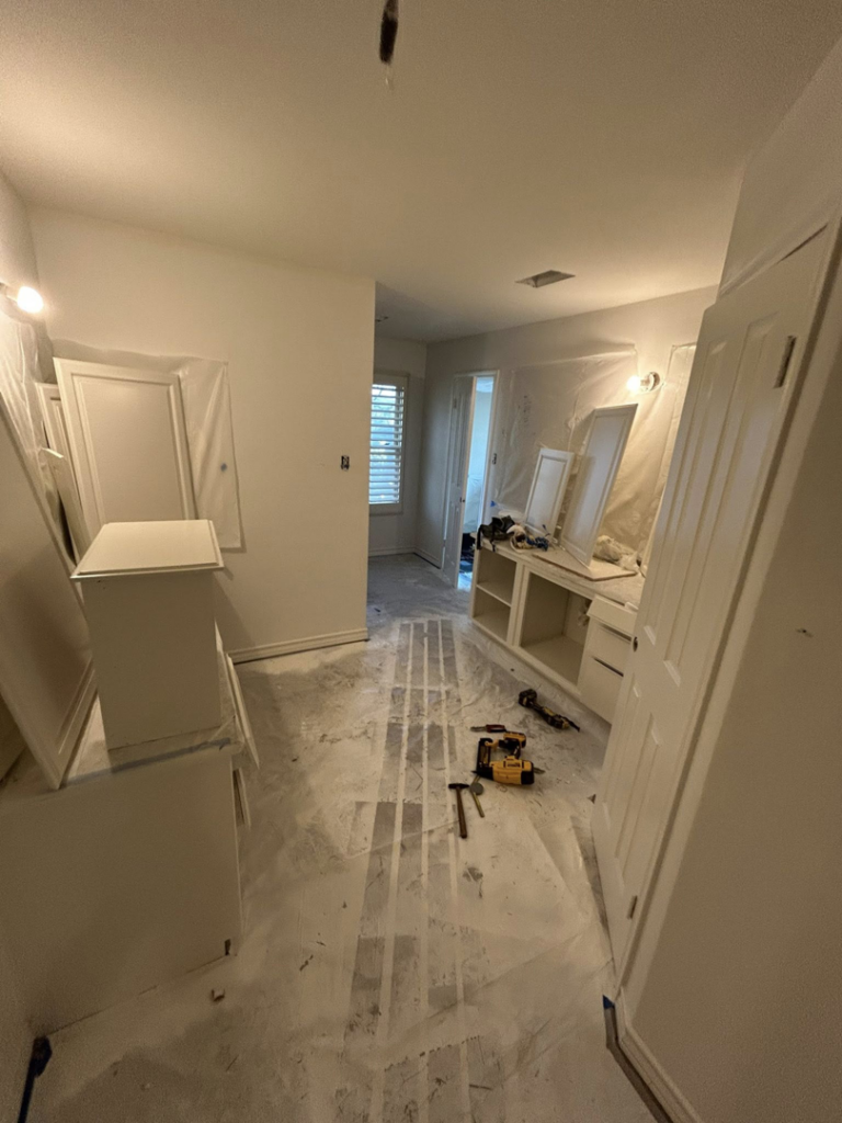 Master bathroom remodel in progress with new vanity installations and protected flooring by Michael South Home Renovations in Fort Worth, TX.