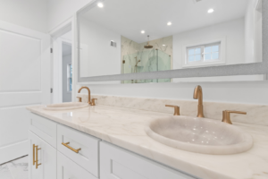 A newly installed master bathroom vanity with double sinks and gold fixtures by EK Construction, LLC in Philadelphia, PA