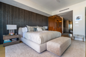 Master bedroom renovation featuring a textured accent wall and integrated shower by J Romano Group in Miami Beach, FL