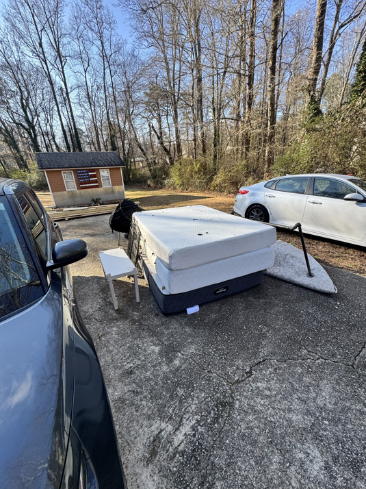Two old mattresses and other items stacked on a driveway for disposal by Eagle Junk Removal in Cloverdale, CA.