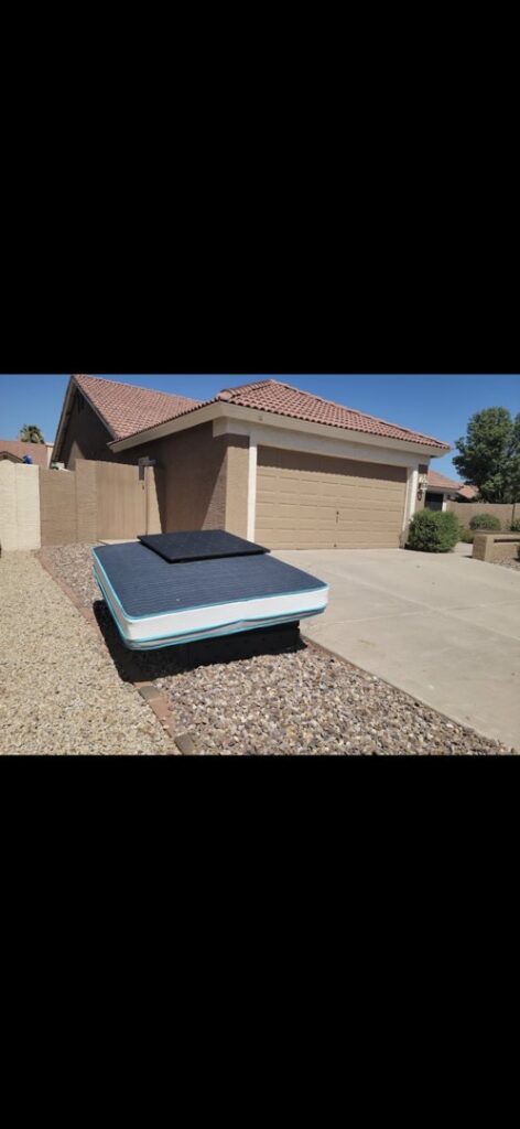 A mattress placed on the rock-covered front yard of a house, awaiting junk removal by The Junkporter Junk Removal in Las Vegas, NV.